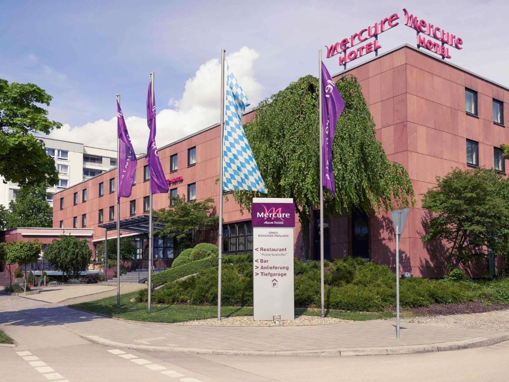 a sign in front of a building with purple flags at Mercure Hotel München Süd Messe in Munich