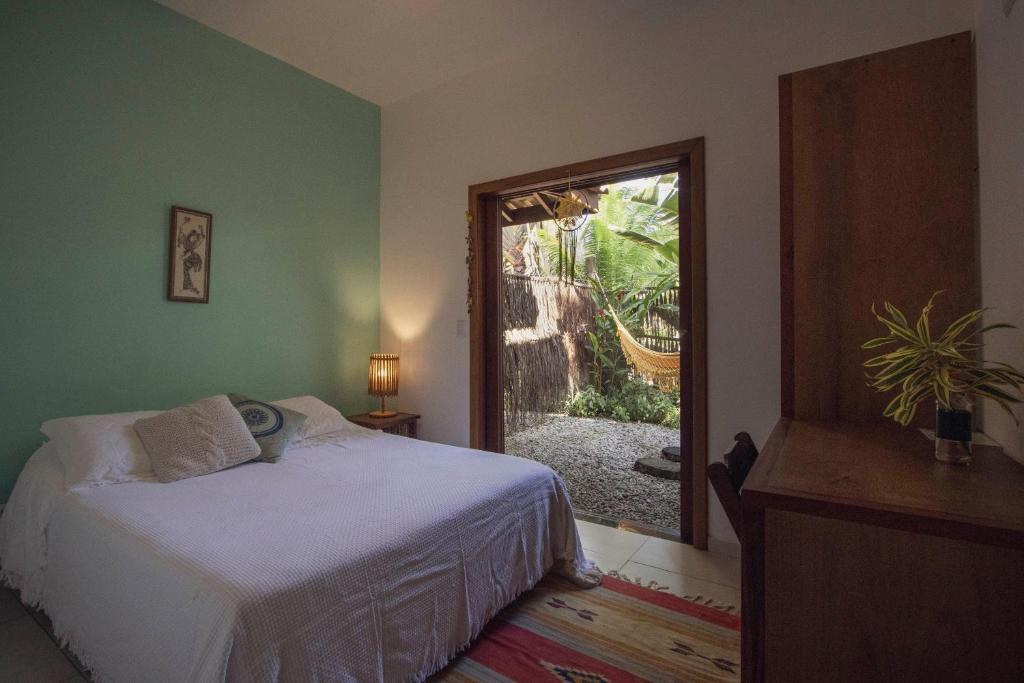 a bedroom with a bed and a large window at Casa Viva Itamambuca in Ubatuba