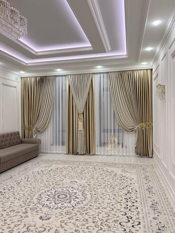 a large living room with a couch and curtains at Guest House Eltin in Bokonbayevo