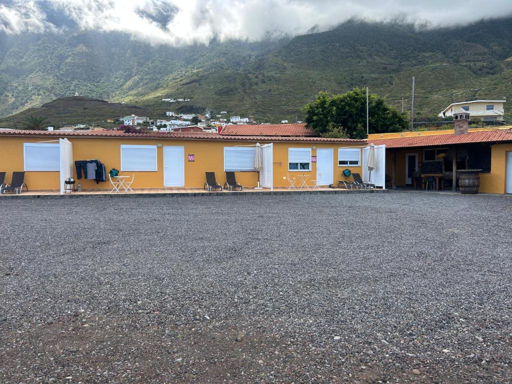 a yellow and white building with mountains in the background at Loft Con Encanto in Frontera
