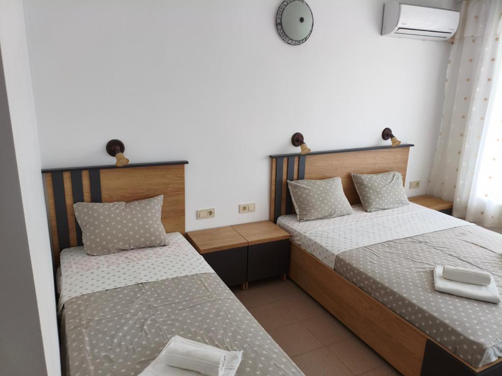a bedroom with two beds and a clock on the wall at Forest Park Kiten in Kiten