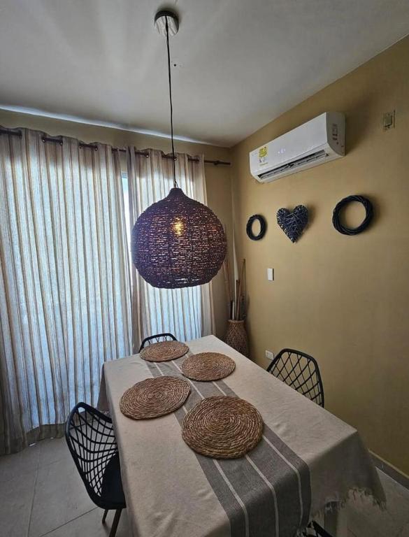 a dining room table with chairs and a purple light at Paraiso Coveñas, Unidad con la mejor piscina in Coveñas