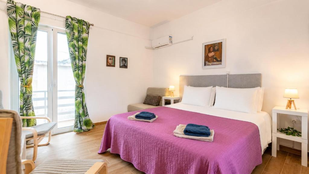 a bedroom with a large bed with a purple blanket at Karavaki apartments in Keri