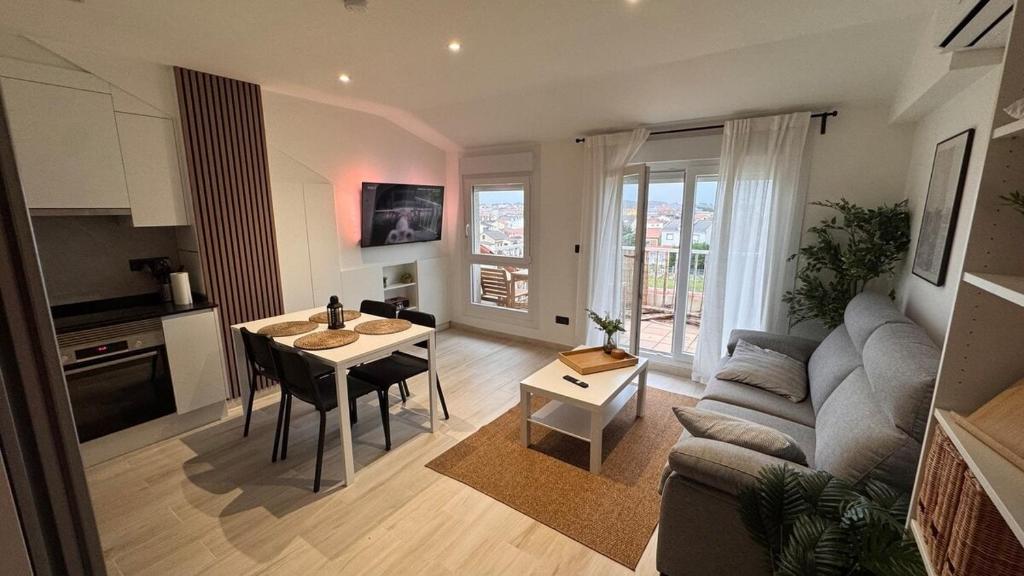 a living room and kitchen with a table and a couch at AuraGalega Vionta in Ribeira