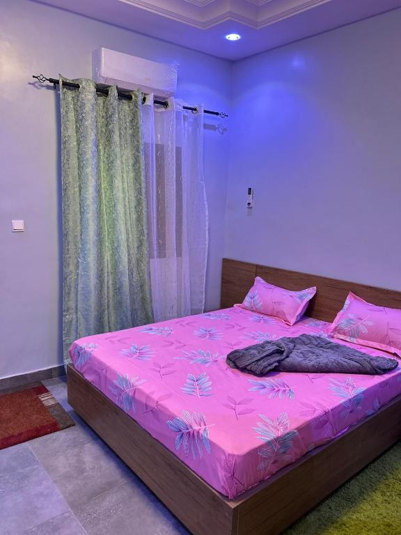 a bedroom with a pink bed with pink sheets at Apartment Luxueux a Cité Apix in Niadyorane