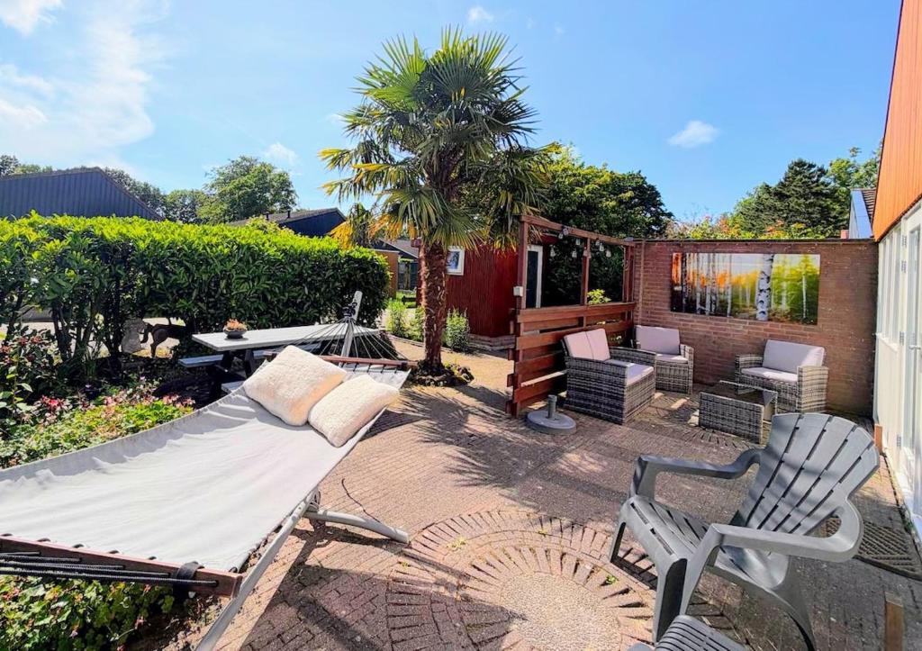 a patio with a couch and chairs and a table at Palm89 in Warmenhuizen