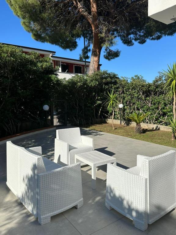 a group of white wicker chairs and a table at Casa Jenny sul mare in Scalea
