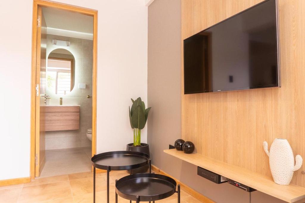 a living room with two tables and a flat screen tv at DEPARTAMENTO en MENDOZA centro, moderno y cálido, Parking - Lavandería in Mendoza