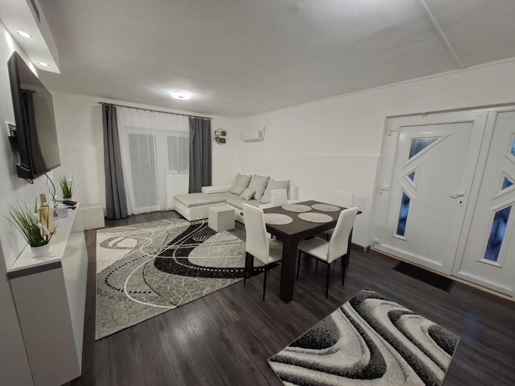 a living room with a table and chairs and a couch at Kakukkfészek Apartmanok in Kiskunmajsa