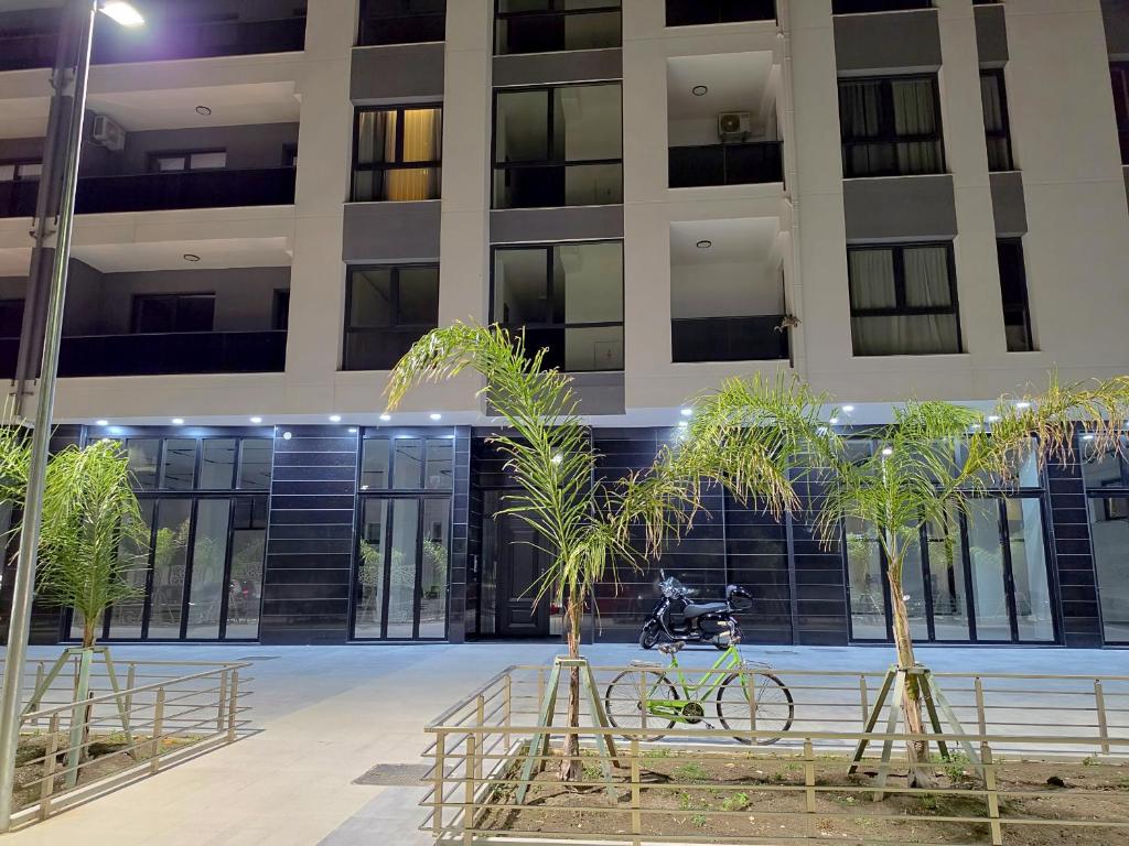a bike parked in front of a building with palm trees at La Dimora Azzurra in Vlorë