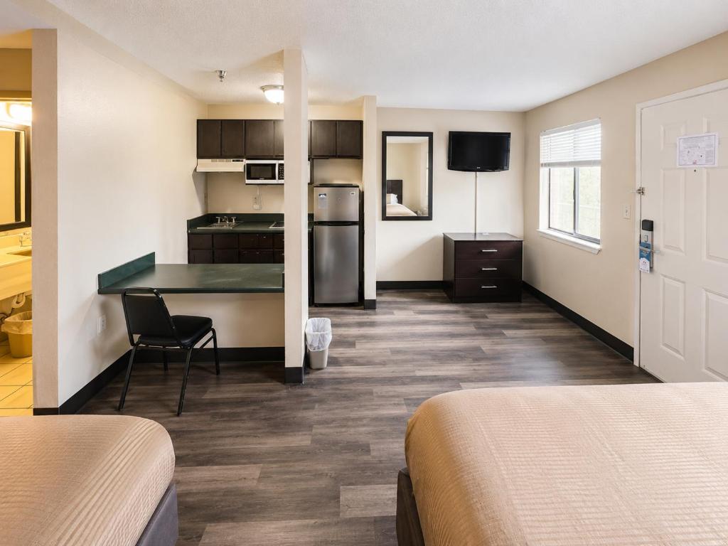 a room with two beds and a kitchen with a table at Studio Lodge of Augusta in Augusta