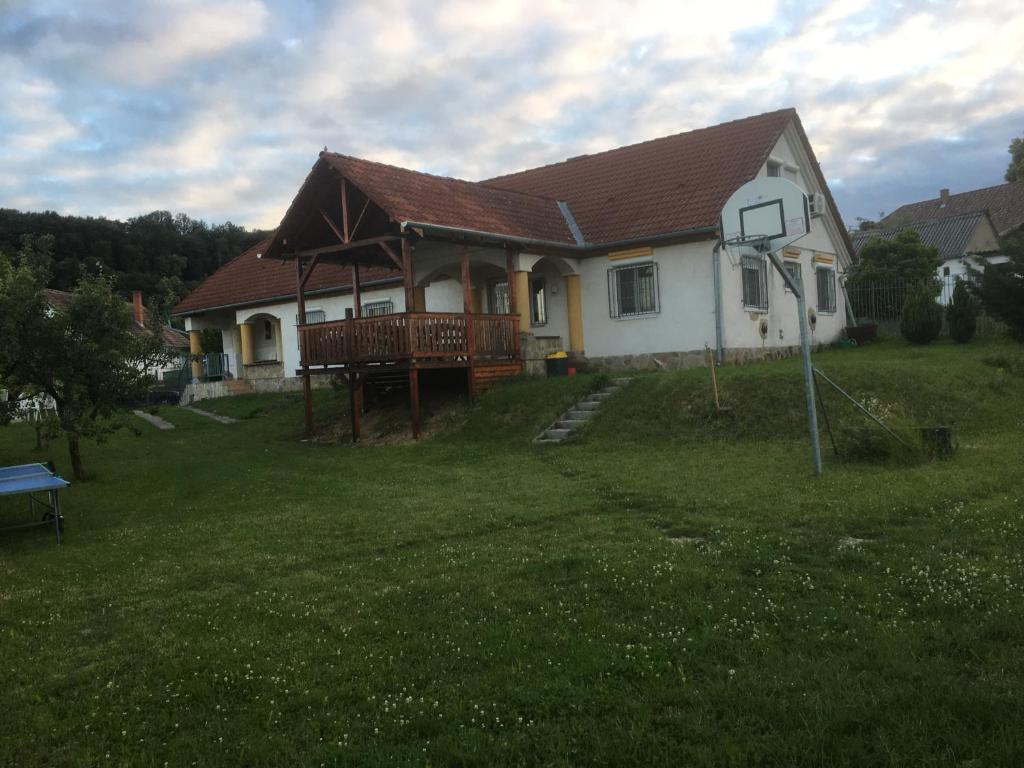a house with a porch and a deck in the yard at Mecseki Farkasvár in Magyarhertelend