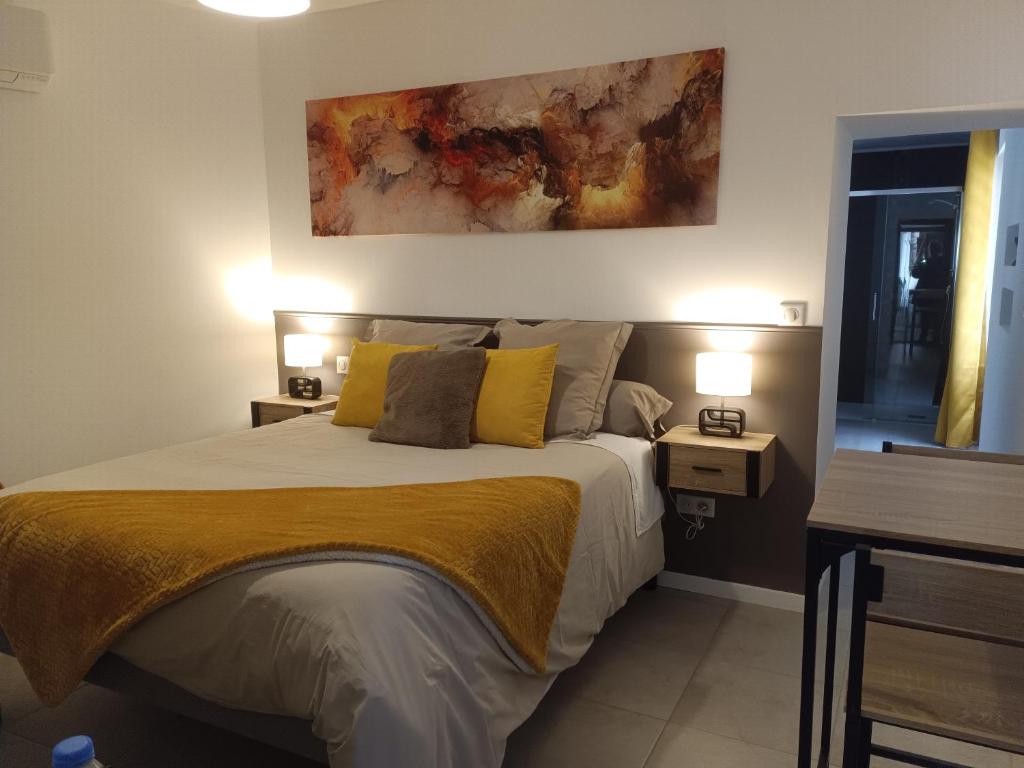 a bedroom with a bed with yellow pillows at Chambre indépendante in Le Vigan