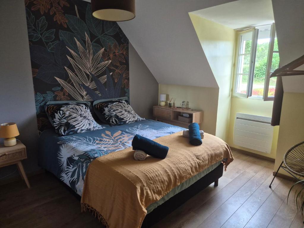 a bedroom with a bed with blue pillows on it at Floralie parking privé navette vers Aéroport ou Gare Beauvais in Saint-Paul