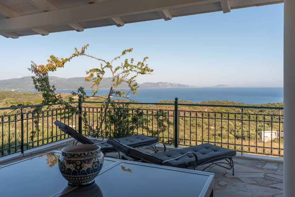 a balcony with a table and chairs and the ocean at Skatza Ocean Crest in Kamária