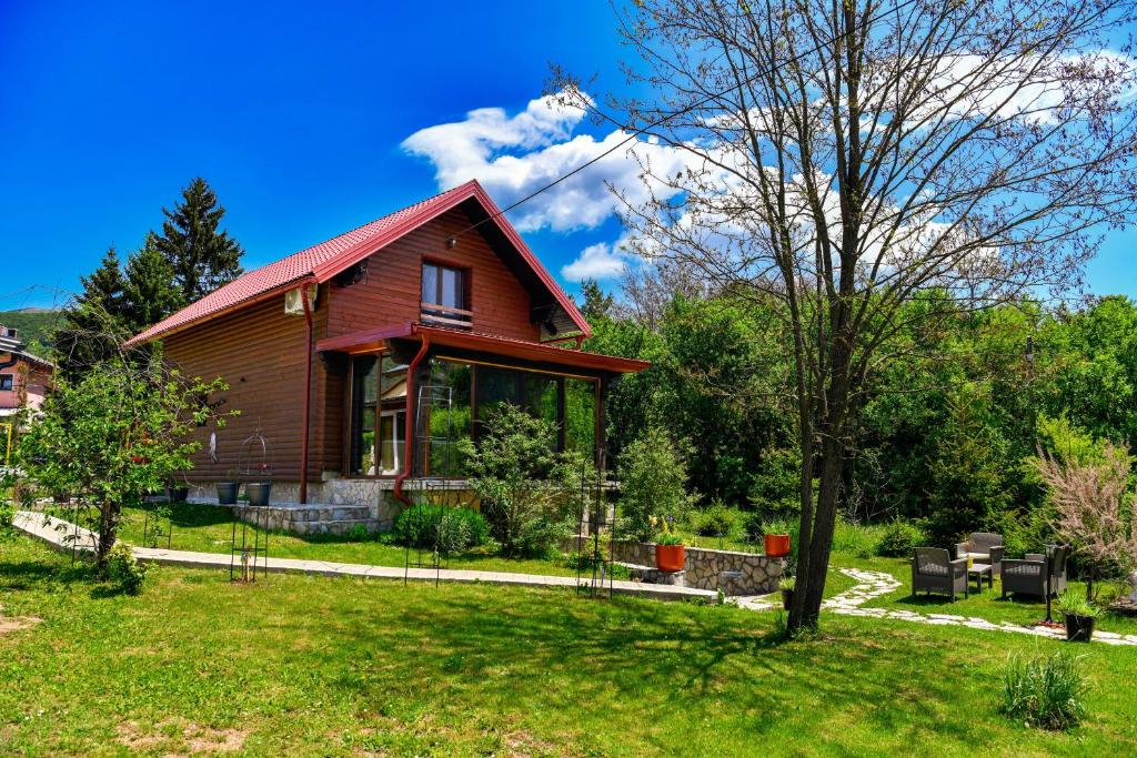 een huis met een rood dak op een groene tuin bij PLITVICE MAGIC in Rudanovac