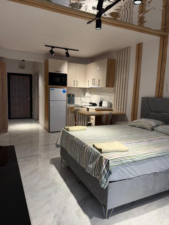 a bedroom with a large bed and a kitchen at Azur Properties 76 in Shkorpilovtsi