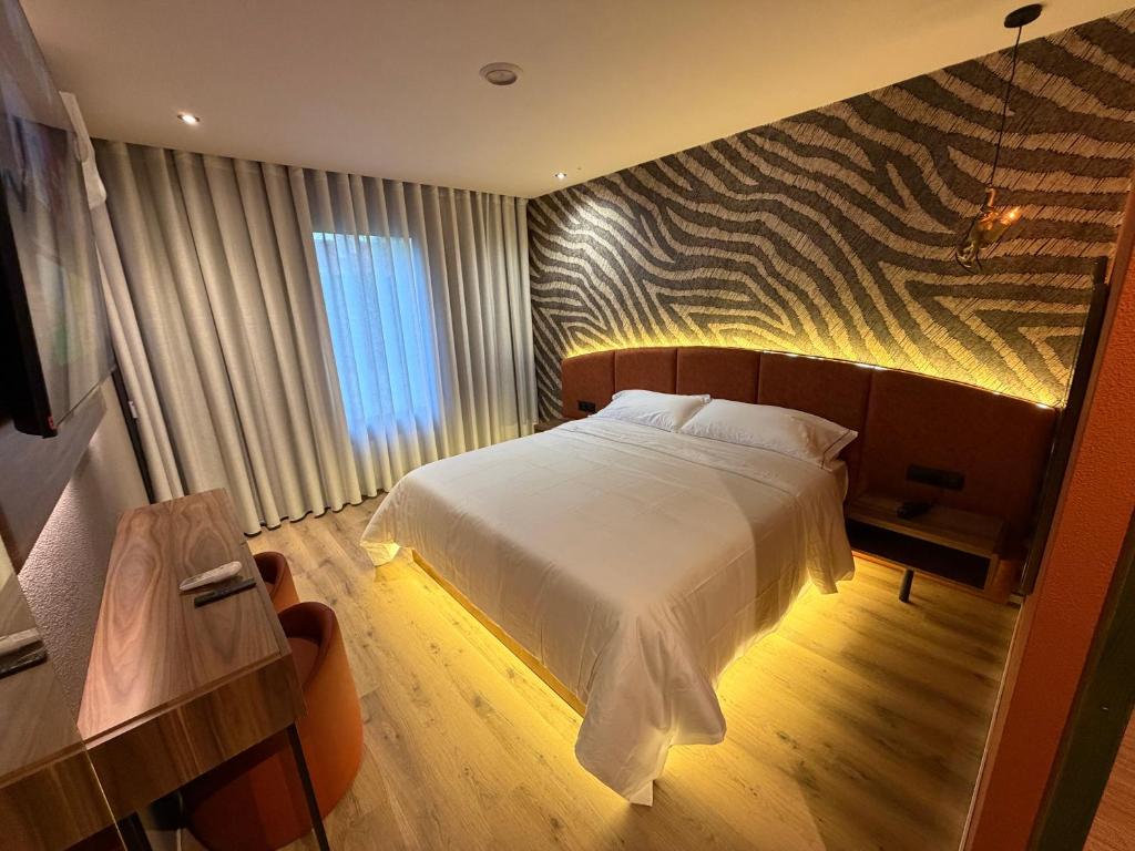 a bedroom with a large white bed in a room at Motel Montecarlo in Teo