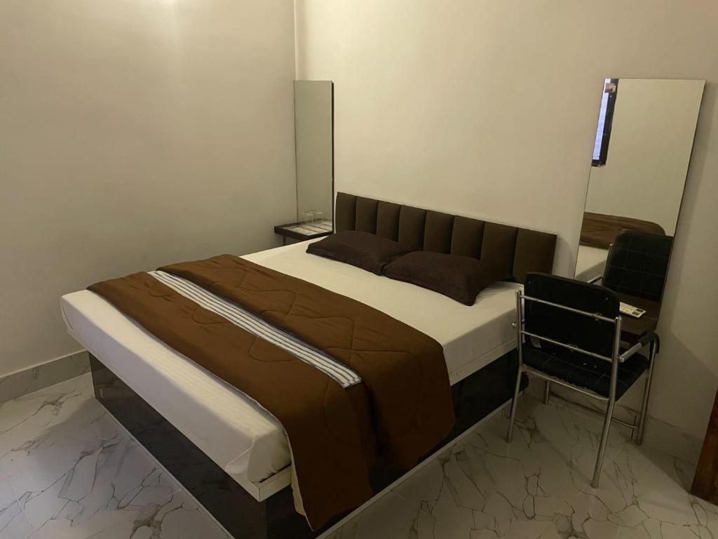 a bedroom with a bed and a chair at SHARDA PALACE Deoghar in Deoghar