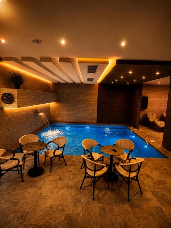 a pool with tables and chairs next to a swimming pool at Emperus Spa in Veliko Gradište