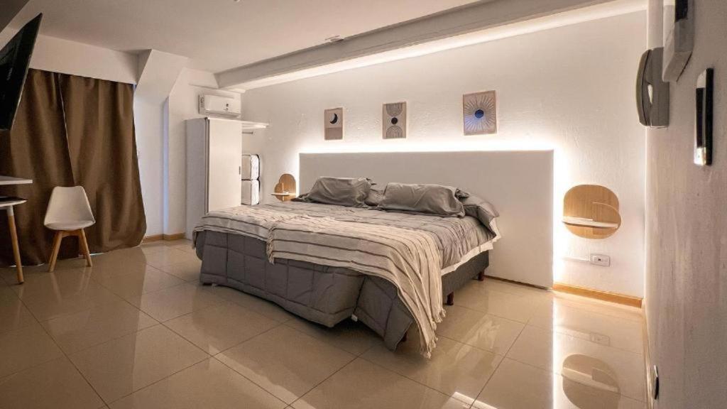 a bedroom with a large bed in a white room at Escobar Apart CENTRO in Belén de Escobar