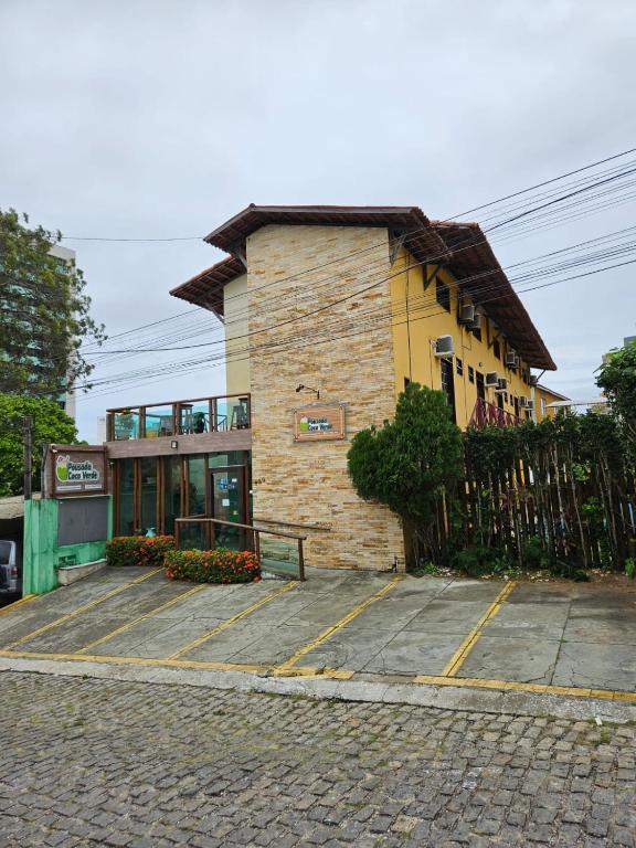 a brick building with a fence in front of it at Pousada Coco Verde Natal in Natal