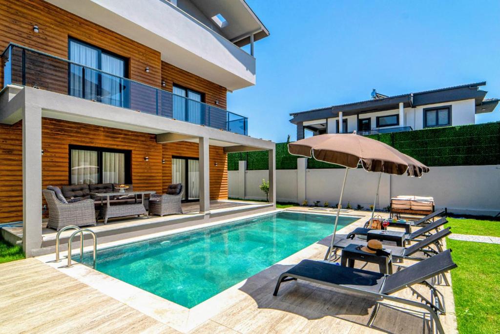 a villa with a swimming pool and a house at Olive villas in Fethiye