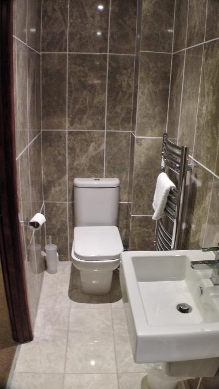 a bathroom with a toilet and a sink at Bay Lodge in Birchington