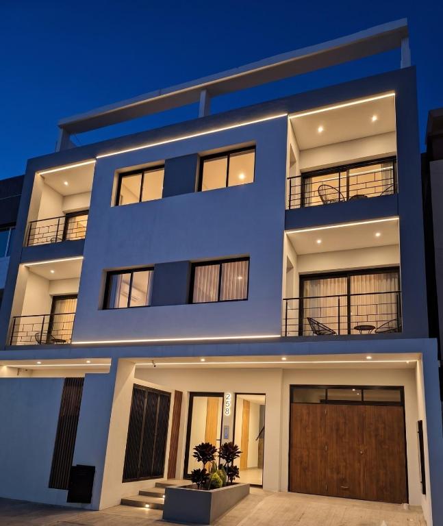 ein blaues Gebäude mit einer Garage bei Nacht in der Unterkunft LEVEL Terrazas premium con parrillas privadas in Bahía Blanca