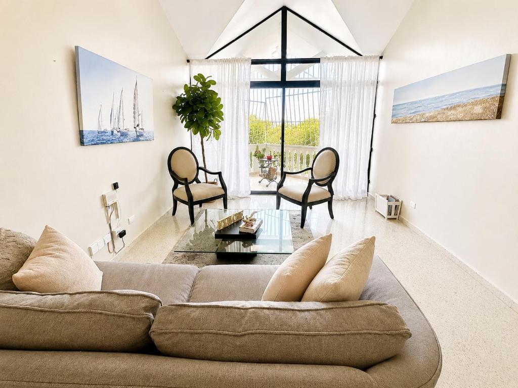 a living room with a couch and chairs at Bright & Modern Apartment in Puerto Plata, Secure, and Central! in San Felipe de Puerto Plata
