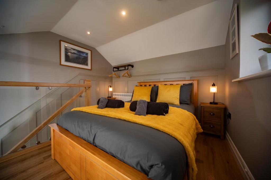 a bedroom with a large bed with yellow sheets at Am Bothan - Pied-à-terre in Portree