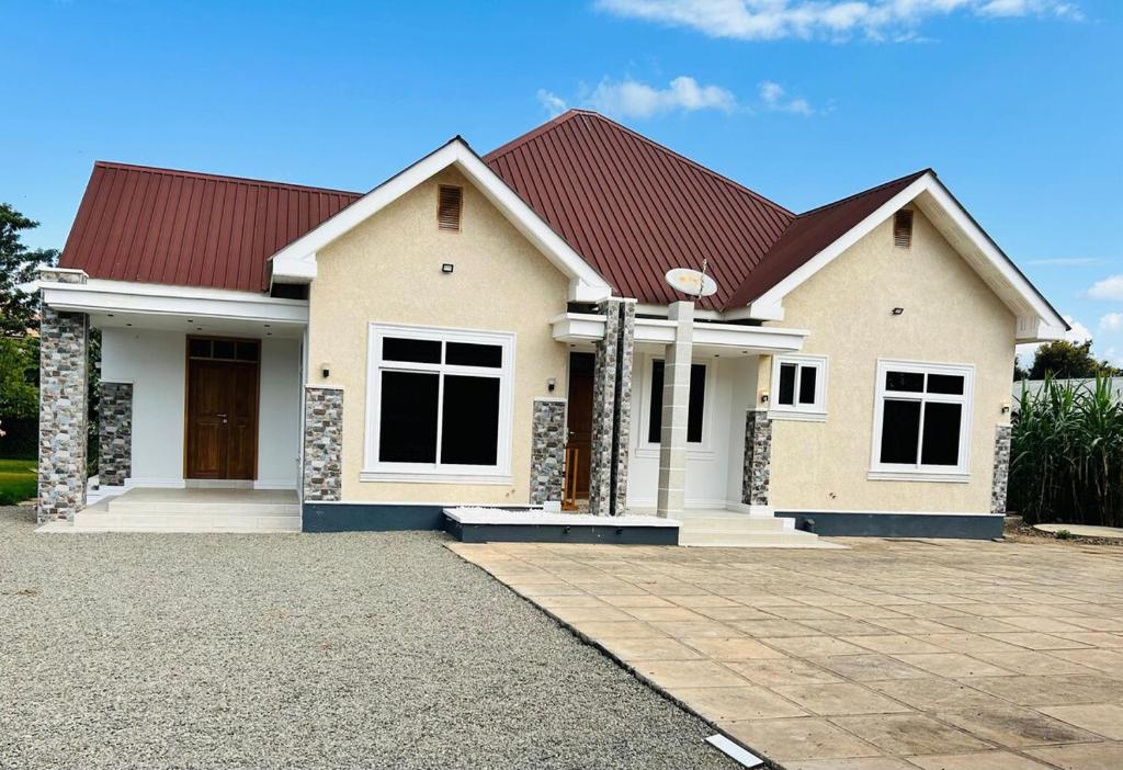 a large white house with a red roof at Hazina Homes in Boma la Ngombe