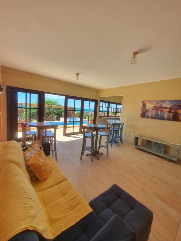 a living room with a couch and a tv at Villa Maze Suites - Canoa Quebrada in Aracati
