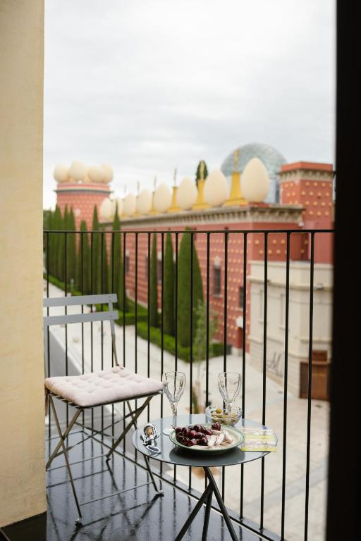 a table with a plate of food on a balcony at Apartamentos enfrente del Museo Dalí - Serena Stays in Figueres