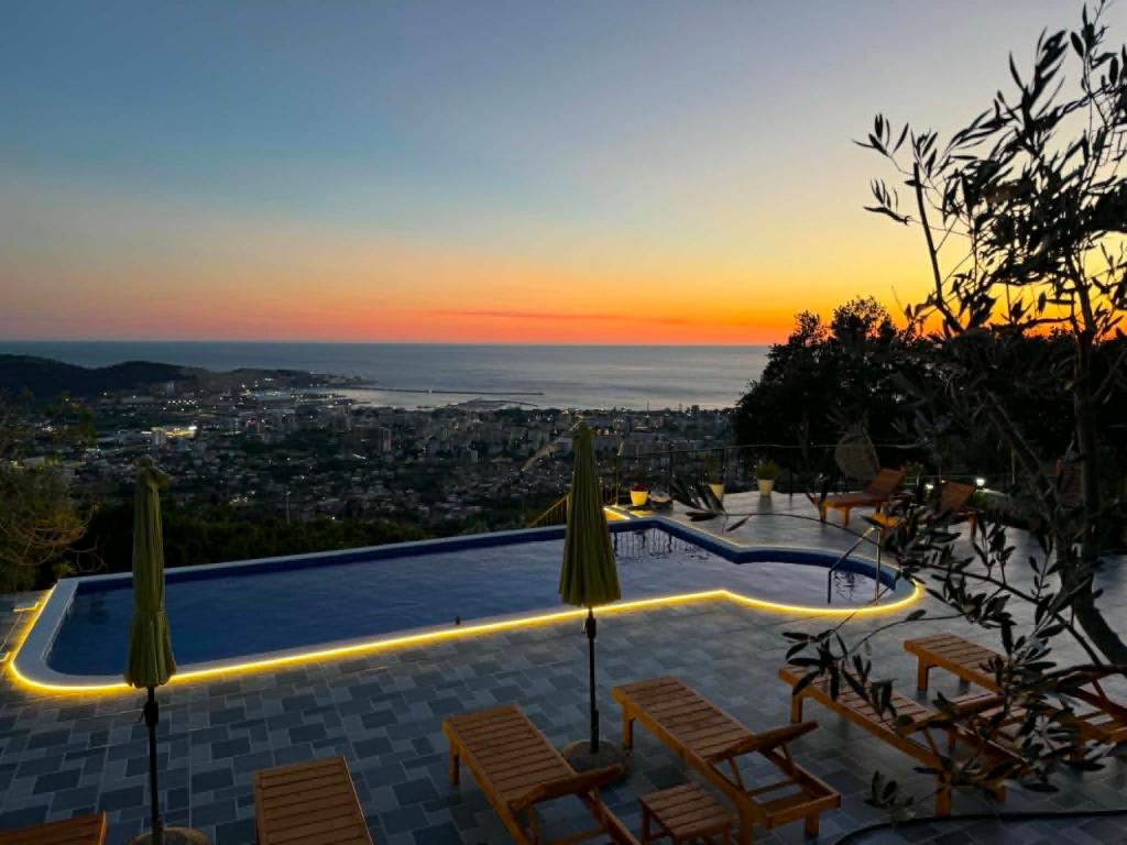a pool with chairs and a sunset in the background at Ranc Mujica in Bar