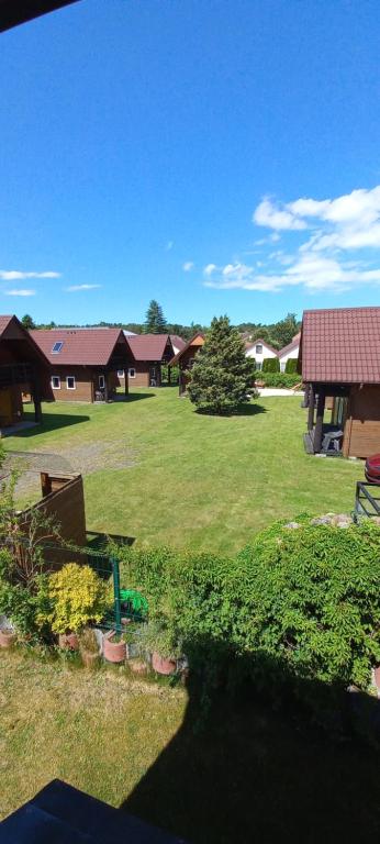 a large yard with houses and a field of grass at Domki ELDORADO in Dębki