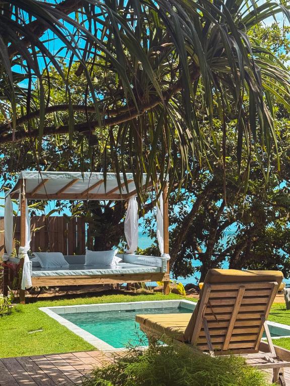 a bed and a chair next to a swimming pool at Villa Mitirapa in Tohautu