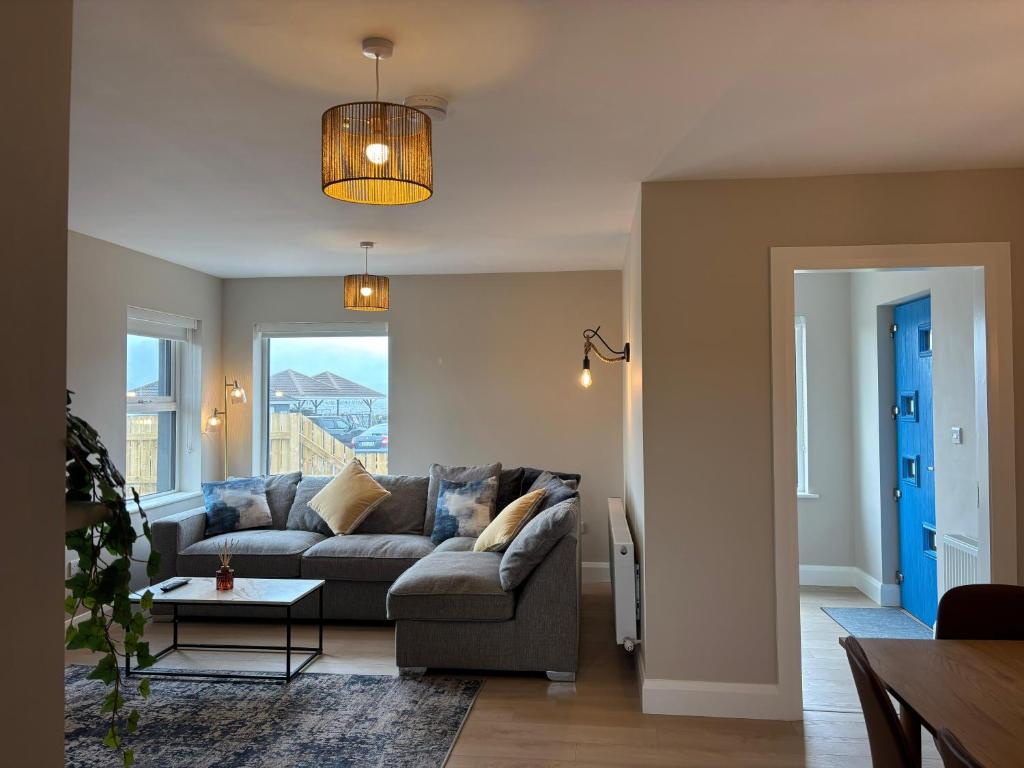 a living room with a couch and a table at Creevy Cove cottage in Kildoney