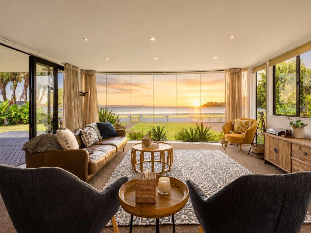 ein Wohnzimmer mit Sofa und Tisch in der Unterkunft Blackpool Bayside - Stay Waiheke in Oneroa