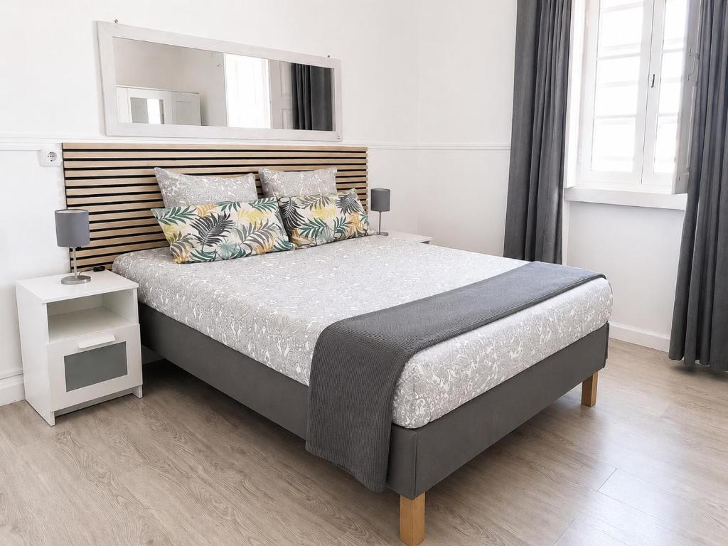 a bedroom with a large bed and a mirror at Casa da Aida - Fuzeta in Fuzeta