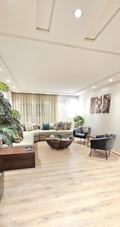 a large living room with a couch and chairs at Andre Luxury Apart in Laayoune