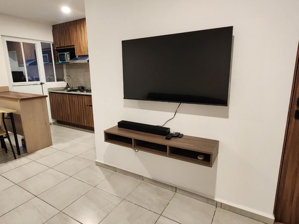 ein Wohnzimmer mit einem Flachbildfernseher an der Wand in der Unterkunft Depa Piky in La Cañada