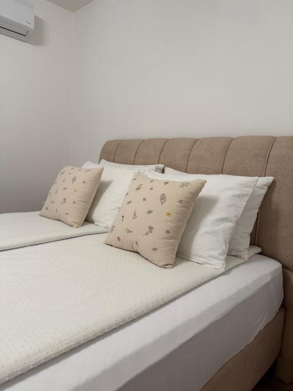 a bed with two pillows on top of it at A&L Luxury Apartment in Tuzla