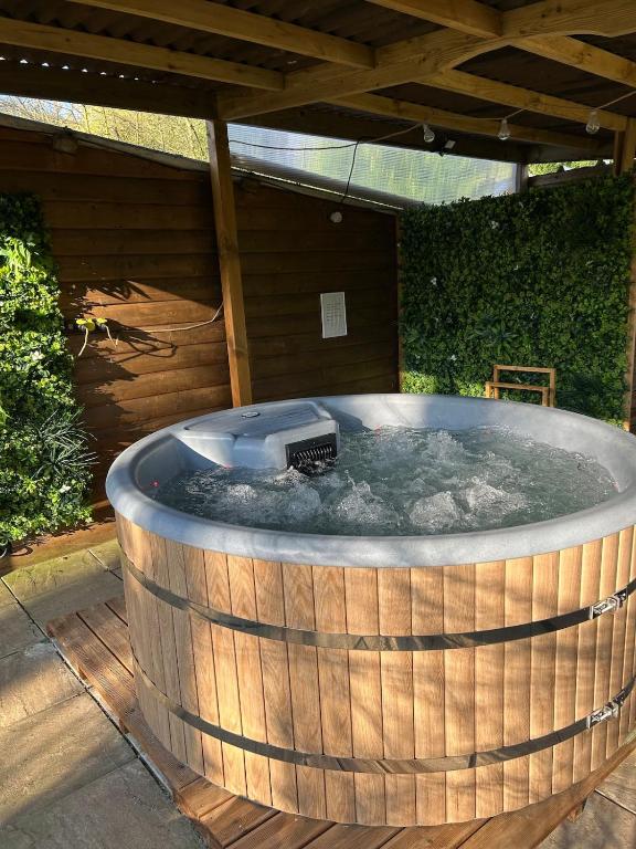 a jacuzzi tub with a grill in a backyard at Chalet dans la nature avec spa in Espins