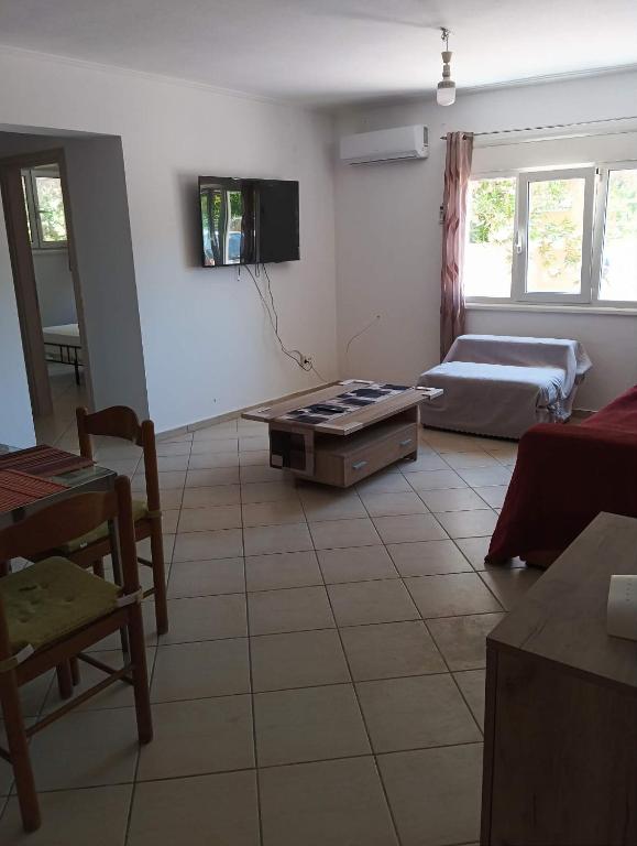 ein Wohnzimmer mit Sofa und Tisch in der Unterkunft Amygdalos Room in Kómi
