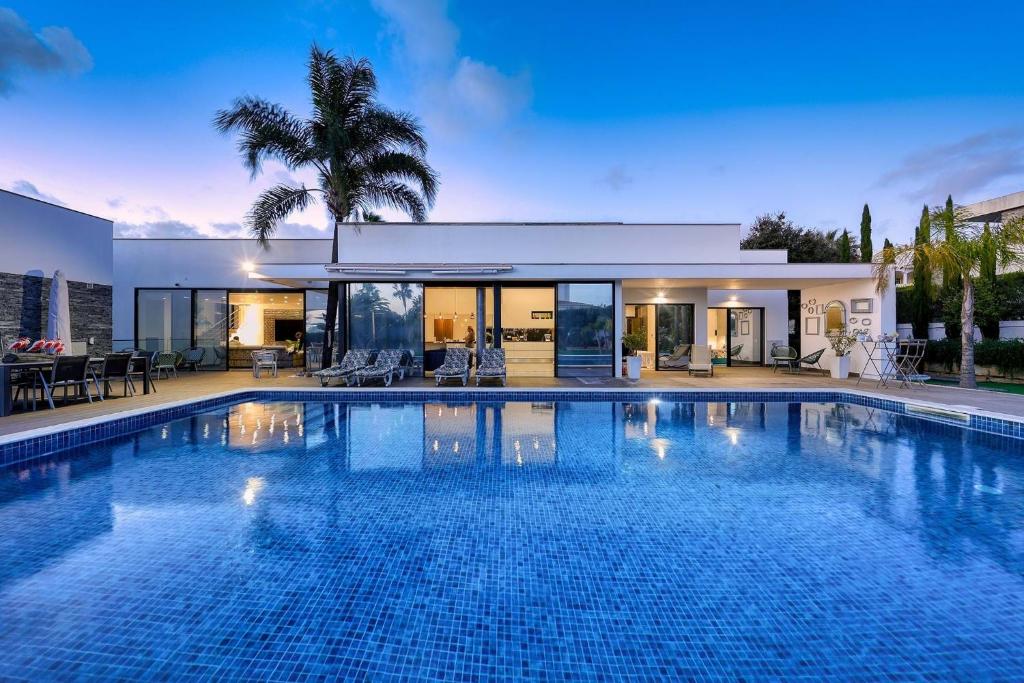 a large swimming pool in front of a house at Palm Suites Algarve in Portimão