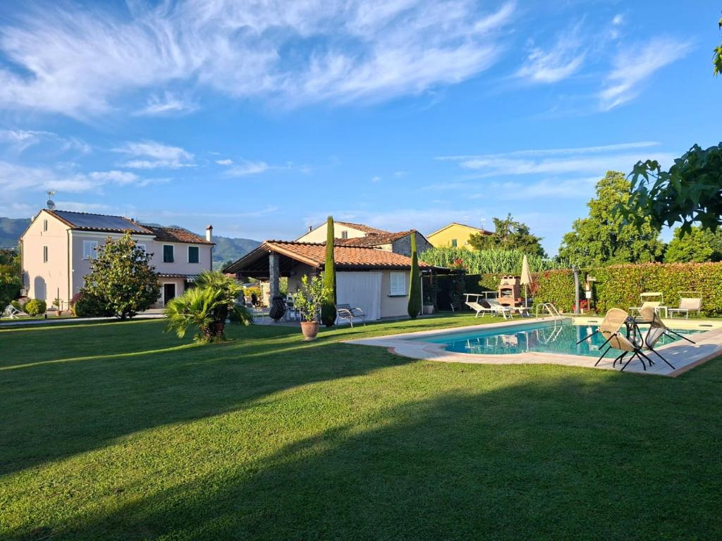 a yard with a swimming pool and a house at Rustico del Chiasso - Villa With Private pool near Lucca in Lucca