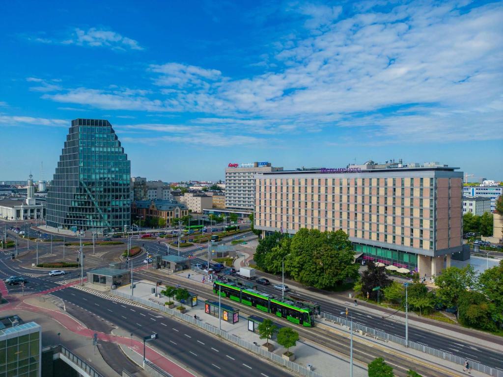 a city with a building and a street with cars at Hotel Mercure Poznań Centrum in Poznań