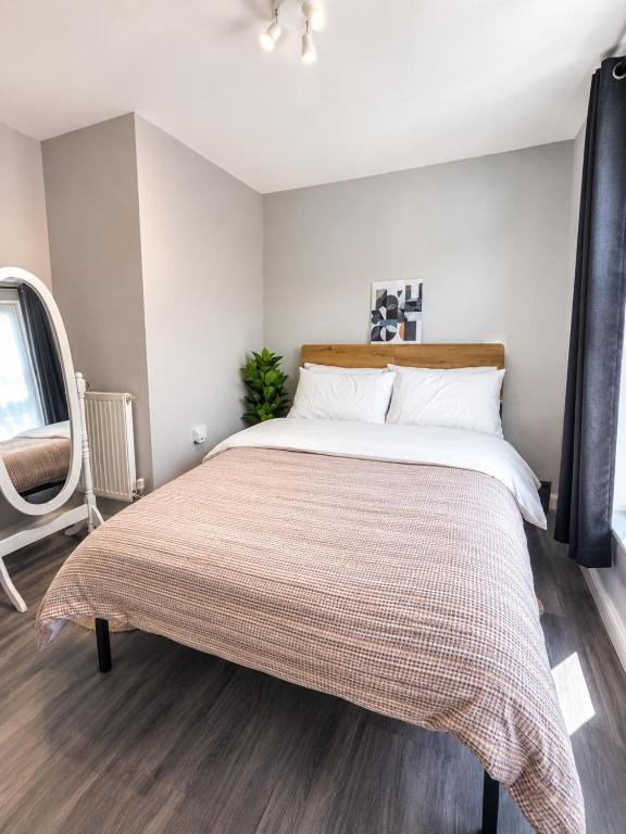 a bedroom with a large bed with a blanket on it at Delwin Place - Quiet Stay & Sparkling Bathroom in Dunstable