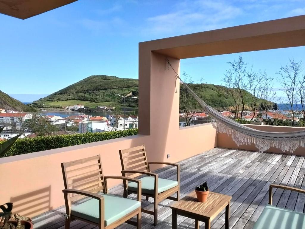a balcony with chairs and a view of the ocean at Dona Emília in Horta